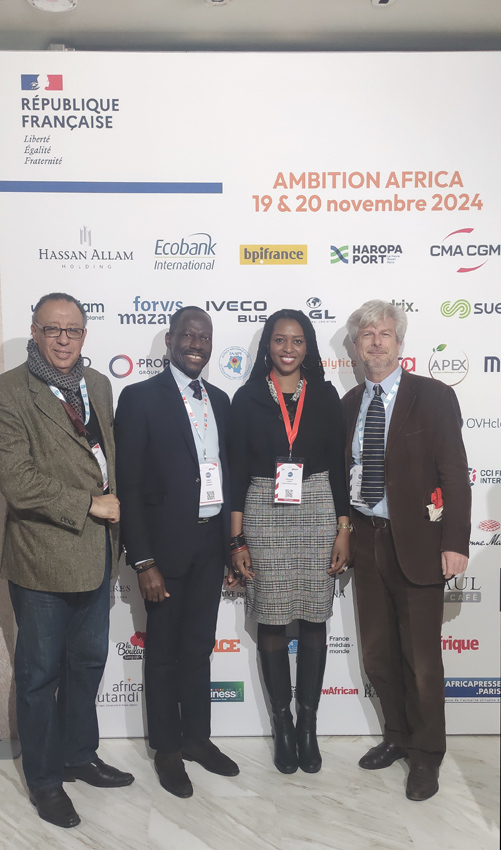 Vier Teilnehmende vor der Veranstaltungswand der Ambition Africa 2024 in Paris
